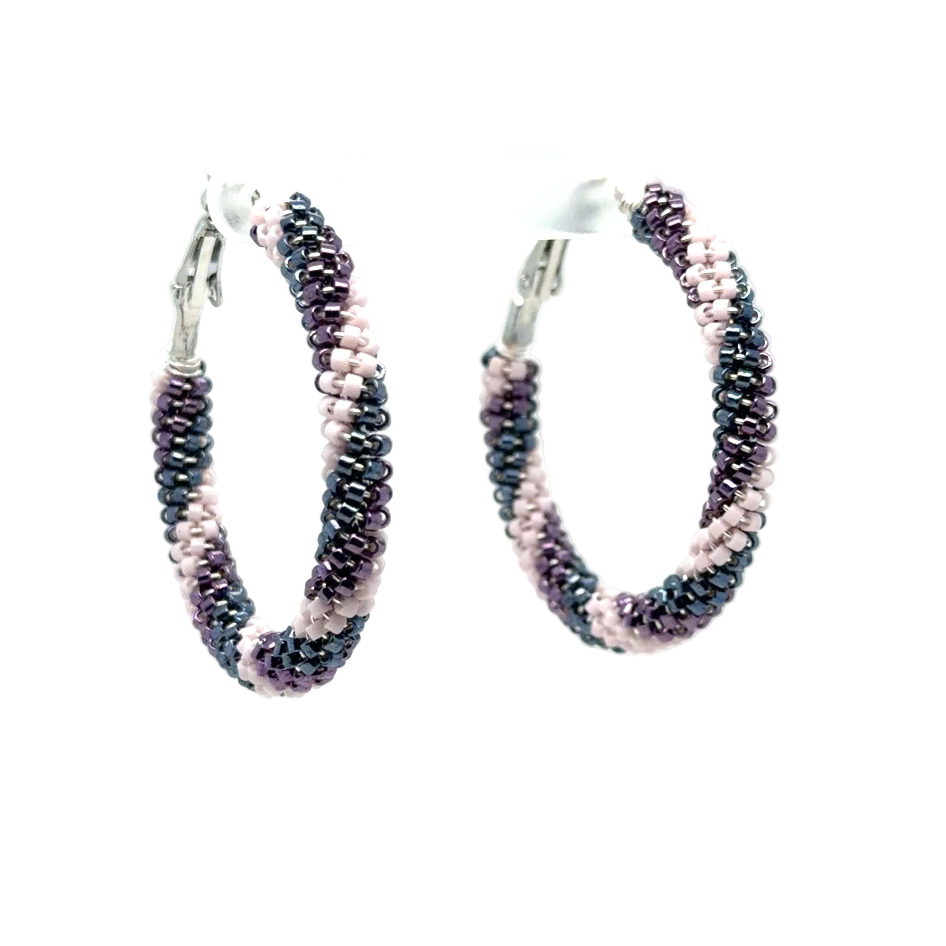 A pair of handmade hoop earrings made from small seed beads in alternating stripes of dark charcoal gray and light pink, with silver-tone metal clasp backs, shown against a plain white background.
