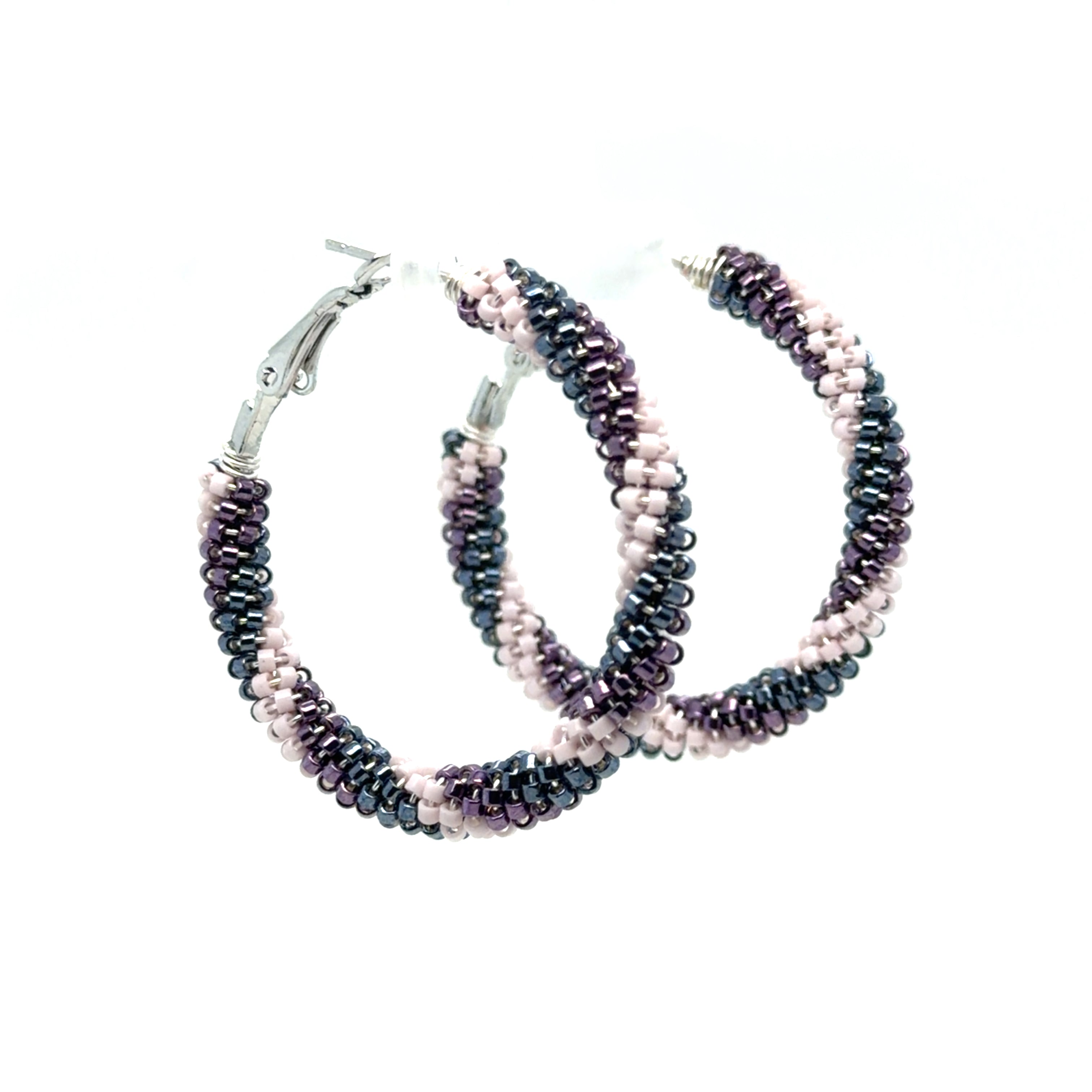 A pair of handmade hoop earrings made from small seed beads woven in stripes of dark charcoal gray, deep purple, and pale pink, with silver-tone metal clasps, shown on a plain white background.