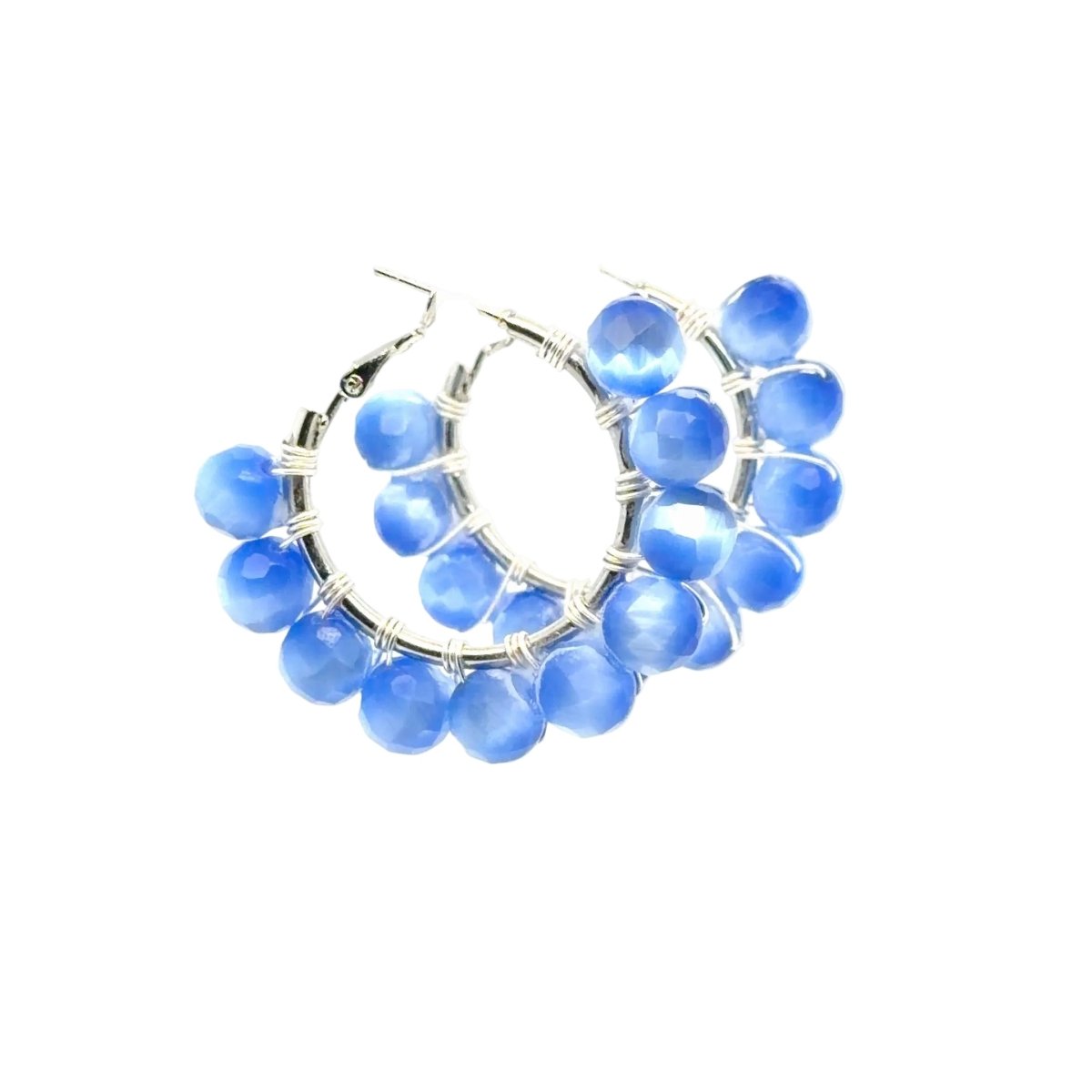 Blue faceted bead hoop earrings with silver wire wrapping and fishhook backings, shown on a plain white background.