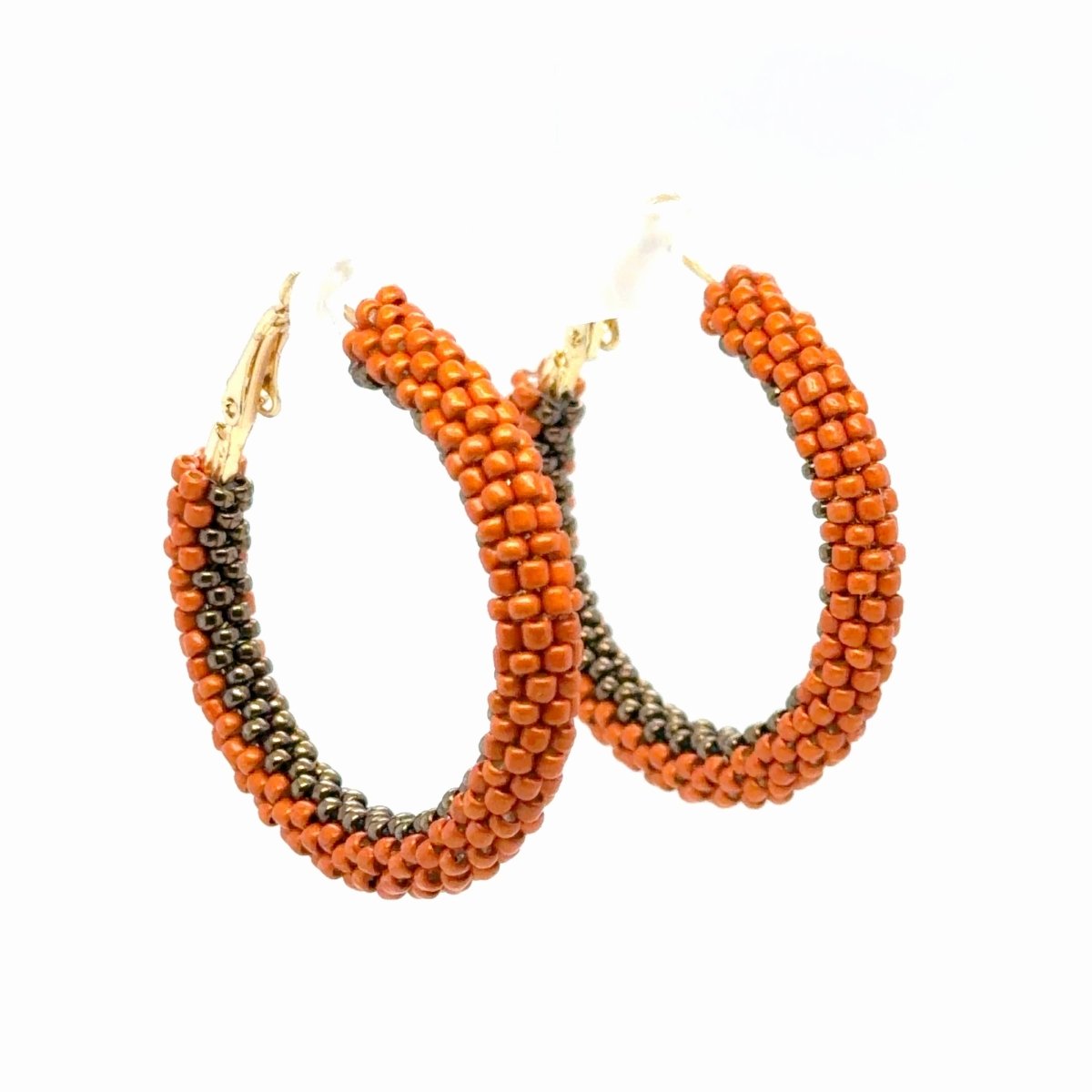 Maeven in Me burnt-orange and gunmetal beaded gold hoop earrings with orange outer rows and a dark metallic inner edge.