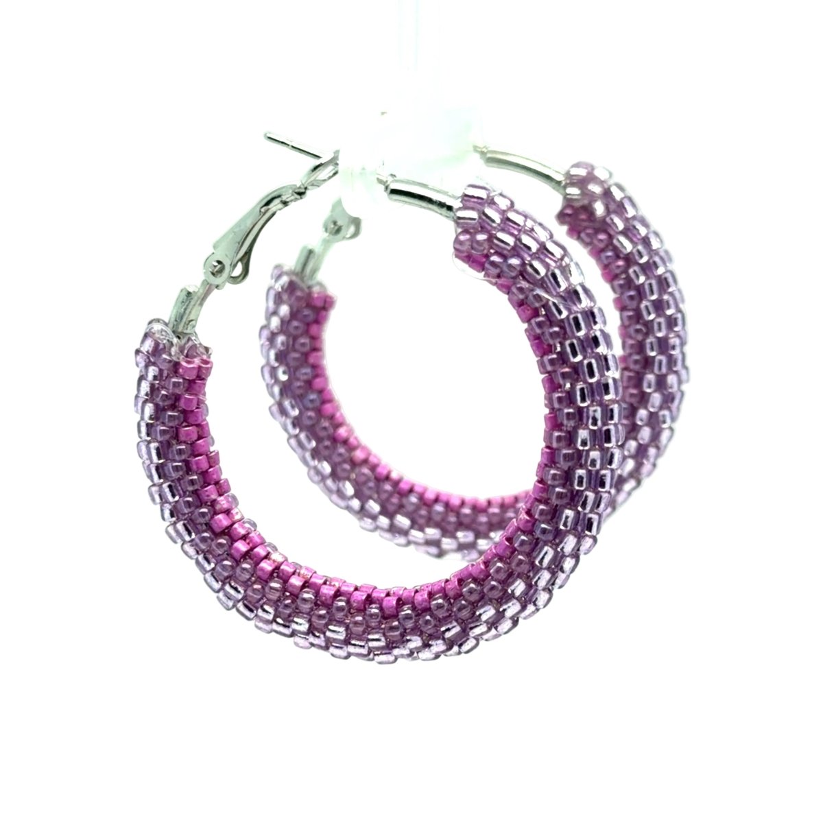 A pair of large hoop earrings made from rows of small faceted beads in shades of pink and purple, with silver-tone clasp backs, shown on a white background.