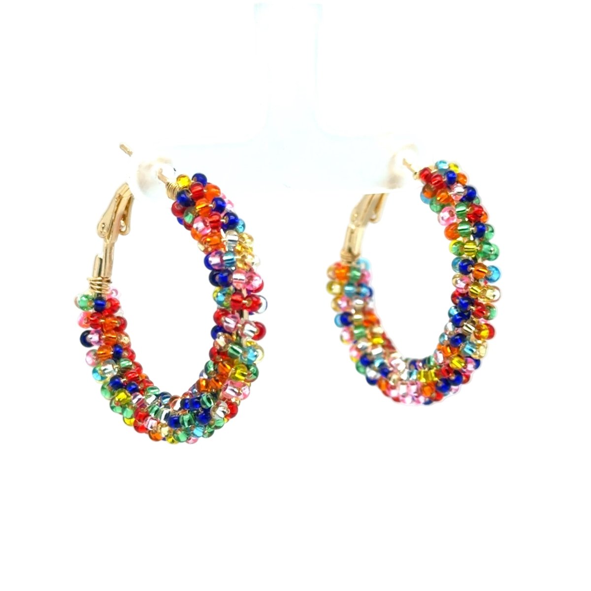 A pair of gold-tone hoop earrings adorned with small, multicolored faceted beads, displayed on a white plastic hanger against a white background.