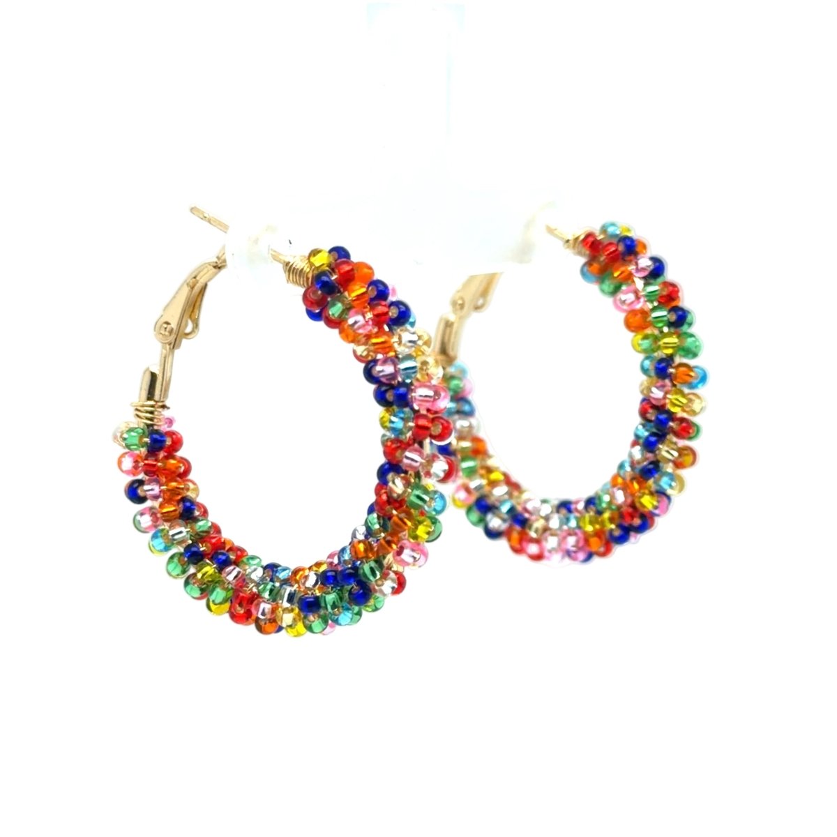 A pair of gold hoop earrings adorned with multiple strands of small, colorful faceted beads in red, orange, yellow, green, blue, and purple, displayed on a white hanger against a white background.