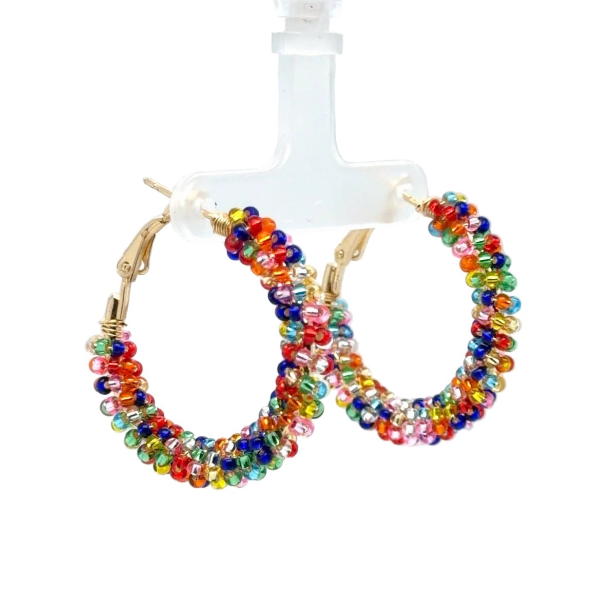 Colorful beaded hoop earrings with gold-tone hardware, displayed on a clear plastic stand against a white background.