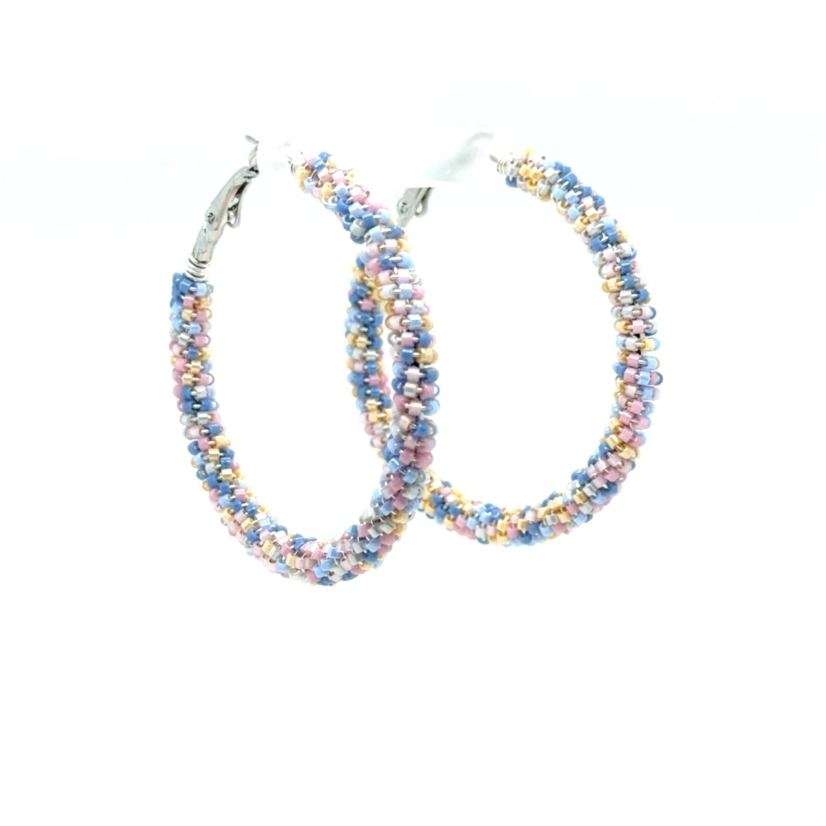 A pair of large hoop earrings made from tightly woven pastel beads in blue, pink, yellow, and white, with silver-tone ear clips, shown on a plain white background.