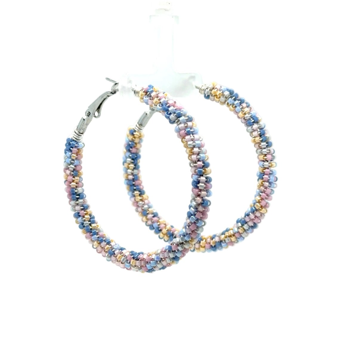 A pair of large hoop earrings made from tightly woven multicolored seed beads in pastel shades of blue, pink, yellow, and white, with silver-tone clasp backs, shown against a plain white background.