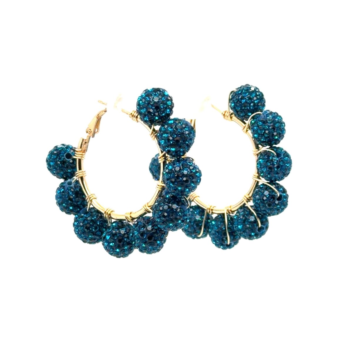 A pair of gold hoop earrings adorned with multiple round, dark teal-blue glittery beads, shown against a plain white background.