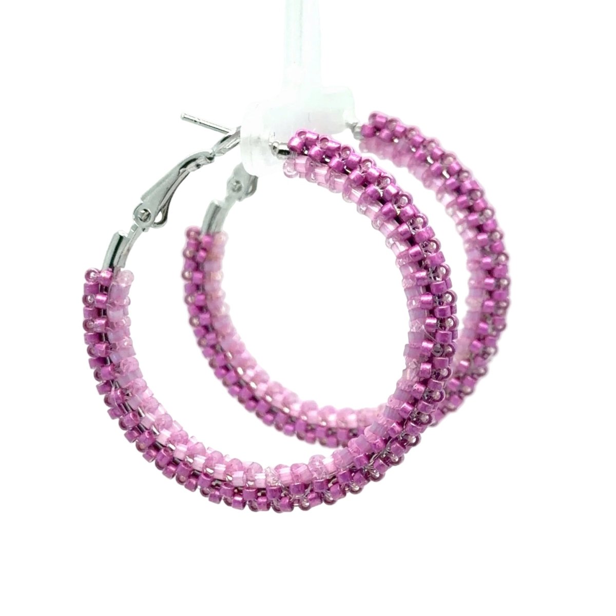 Pink beaded hoop earrings with silver-tone clasp backs, shown hanging against a light gray background.